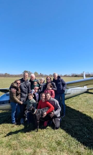Familia reunida junto a un planeador en la pista